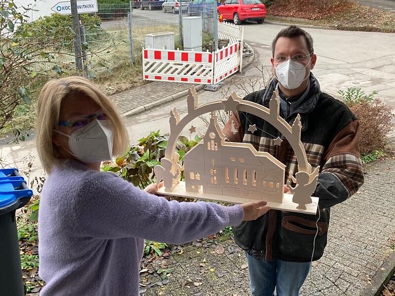 Foto:Übergabe eines Schwibbogens mit der evangelischen Kirche